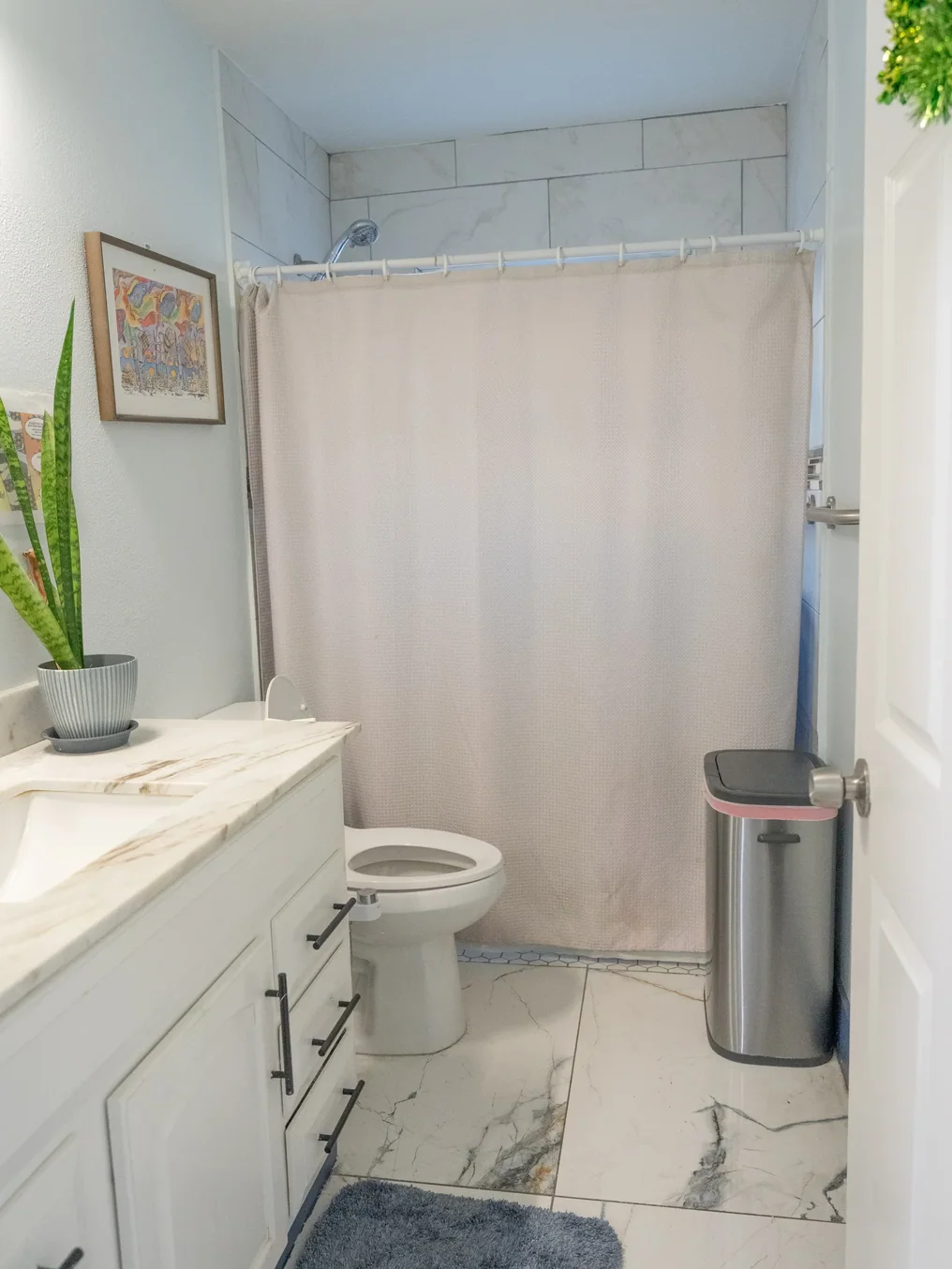 Accessible bathroom with walk-in shower, marble countertop vanity, and wide layout for easy mobility