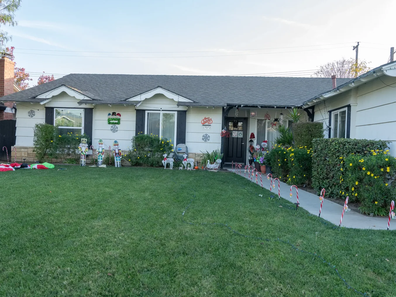 Front exterior view of single-story residential care home with well-maintained lawn and seasonal decorations